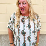 White linen blouse with green and brown boho-inspired pattern and elasticized sleeves