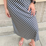 Ivory and navy satin maxi skirt featuring diagonal stripes and a flowing bias-cut silhouette.