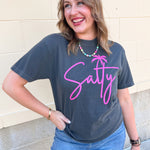 Charcoal gray graphic t-shirt featuring pink script "Salty" lettering with a palm tree graphic on the front.