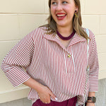 Off-white and garnet striped blouse with a collared neckline, 3/4 length sleeves, gold button detail, and hi-low hem.