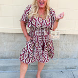 Garnet Aztec print knee-length dress with flutter sleeves, deep V-neckline, cinched waist, and flowy skirt.