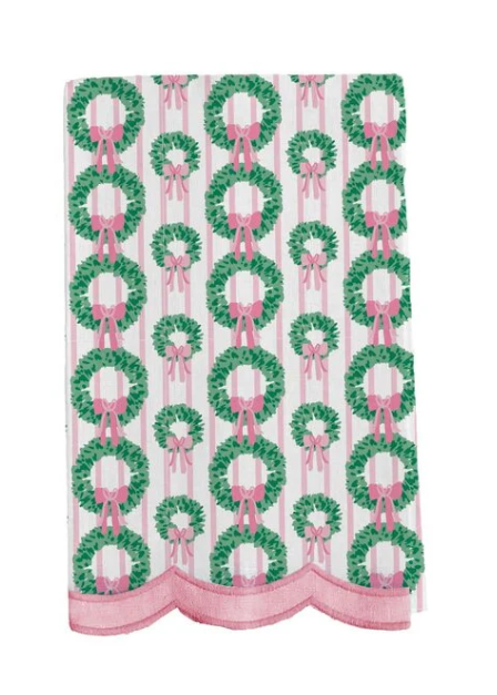 White Christmas tea towel with green wreaths, pink bows, pink stripes, and scalloped pink trim.