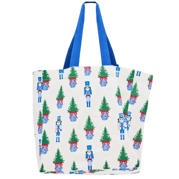 White everyday tote with nutcracker and Christmas tree print and blue handles.