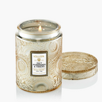 Small luxury candle in embossed glass jar with matching lid.