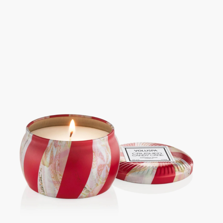 Mini holiday candle in candy cane patterned tin with matching lid.