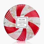 Holiday candle in festive candy cane patterned tin with three wicks and matching lid.