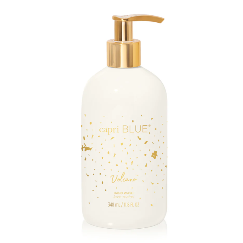 Capri Blue Volcano Hand Wash 11.7oz with white bottle, tropical illustrations, and gold accents.