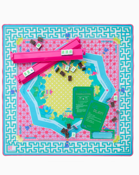 Colorful Mahjong mat with teal, neon pink, and yellow geometric design, rolled with canvas bag