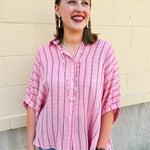 Oversized pink striped cotton gauze blouse with collar, button-down front, drop shoulders, and half sleeves.