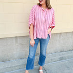 Oversized pink striped cotton gauze blouse with collar, button-down front, drop shoulders, and half sleeves.