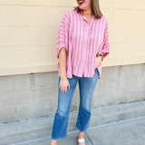 Oversized pink striped cotton gauze blouse with collar, button-down front, drop shoulders, and half sleeves.