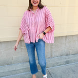 Oversized pink striped cotton gauze blouse with collar, button-down front, drop shoulders, and half sleeves.