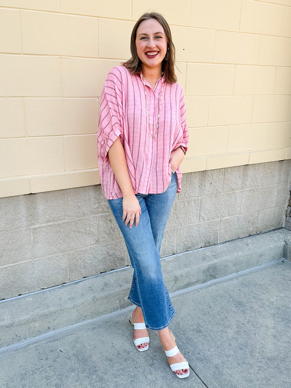 Oversized pink striped cotton gauze blouse with collar, button-down front, drop shoulders, and half sleeves.