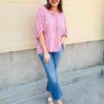 Oversized pink striped cotton gauze blouse with collar, button-down front, drop shoulders, and half sleeves.