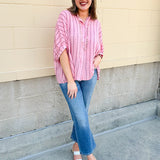 Oversized pink striped cotton gauze blouse with collar, button-down front, drop shoulders, and half sleeves.