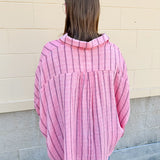 Oversized pink striped cotton gauze blouse with collar, button-down front, drop shoulders, and half sleeves.