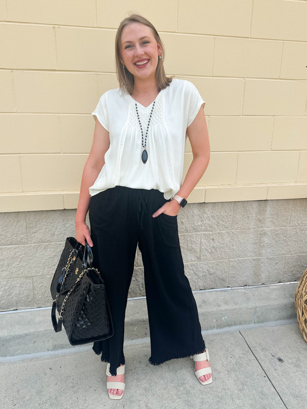  Neutral short sleeve top with smocking and pleated details, styled for a casual polished look