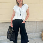  Neutral short sleeve top with smocking and pleated details, styled for a casual polished look