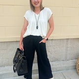  Neutral short sleeve top with smocking and pleated details, styled for a casual polished look