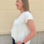  Neutral short sleeve top with smocking and pleated details, styled for a casual polished look