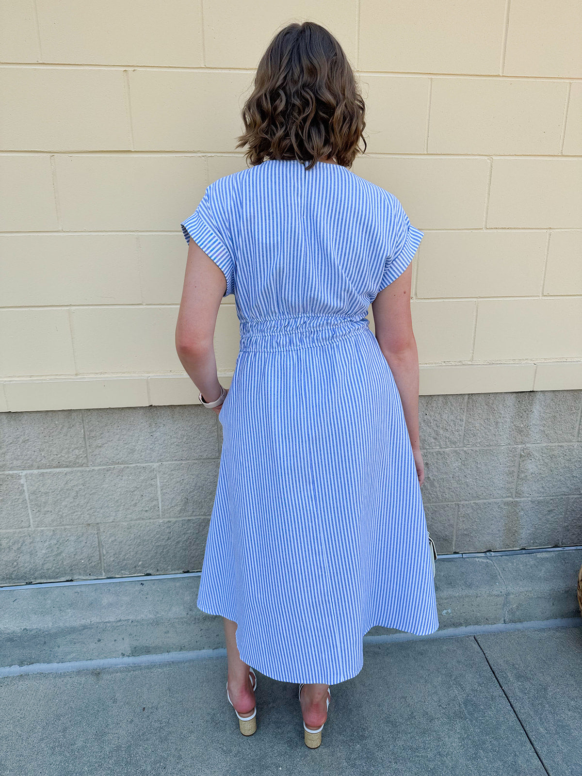 Model wearing the Skyline Views Striped Midi Dress with a classic striped pattern, cuffed short sleeves, and an elastic waistline – styled for a breezy, sun-soaked summer day by the coast or in the city