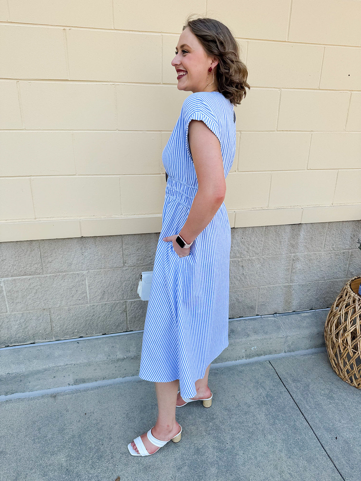 Model wearing the Skyline Views Striped Midi Dress with a classic striped pattern, cuffed short sleeves, and an elastic waistline – styled for a breezy, sun-soaked summer day by the coast or in the city