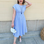 Model wearing the Skyline Views Striped Midi Dress with a classic striped pattern, cuffed short sleeves, and an elastic waistline – styled for a breezy, sun-soaked summer day by the coast or in the city