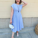Model wearing the Skyline Views Striped Midi Dress with a classic striped pattern, cuffed short sleeves, and an elastic waistline – styled for a breezy, sun-soaked summer day by the coast or in the city