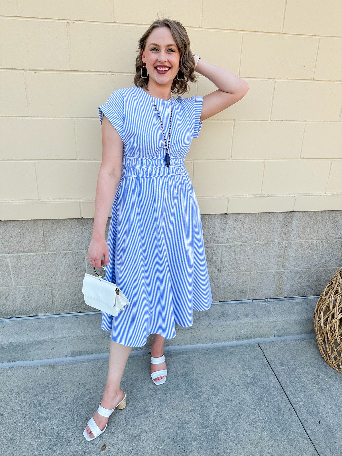 Model wearing the Skyline Views Striped Midi Dress with a classic striped pattern, cuffed short sleeves, and an elastic waistline – styled for a breezy, sun-soaked summer day by the coast or in the city