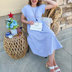 Model wearing the Skyline Views Striped Midi Dress with a classic striped pattern, cuffed short sleeves, and an elastic waistline – styled for a breezy, sun-soaked summer day by the coast or in the city
