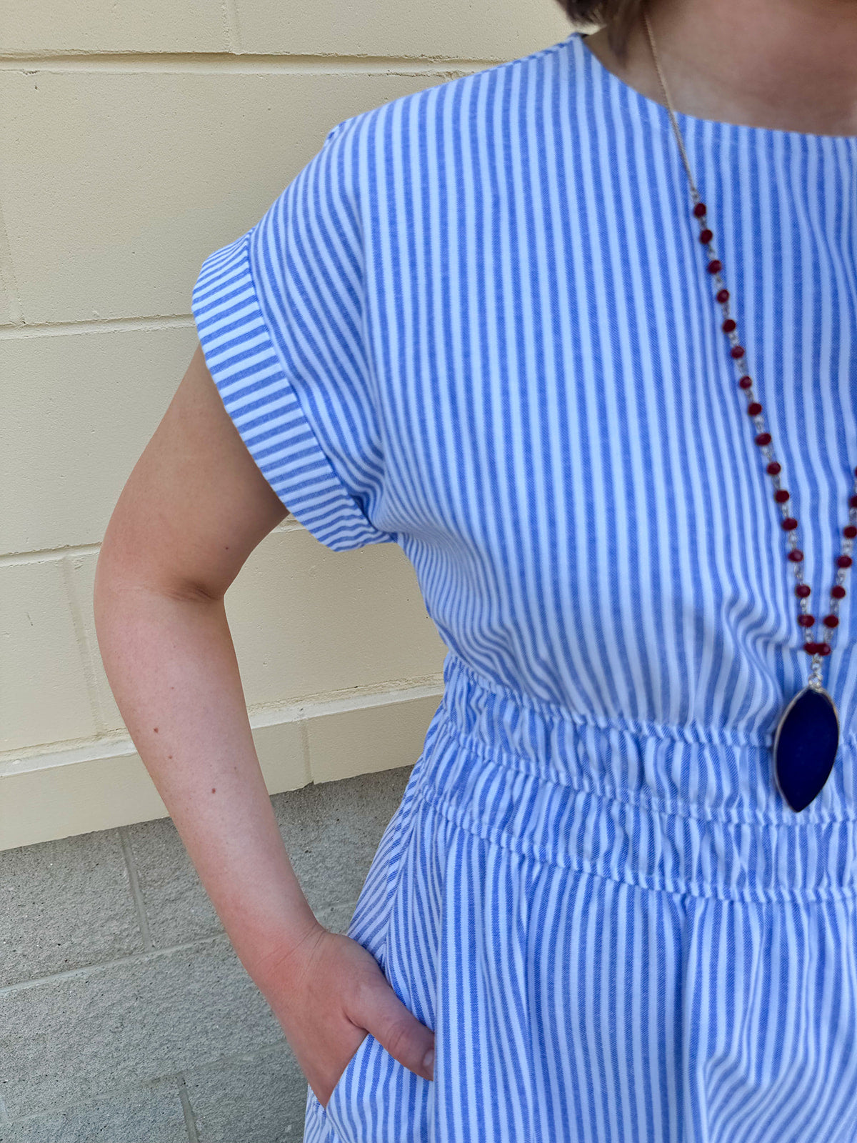 Model wearing the Skyline Views Striped Midi Dress with a classic striped pattern, cuffed short sleeves, and an elastic waistline – styled for a breezy, sun-soaked summer day by the coast or in the city