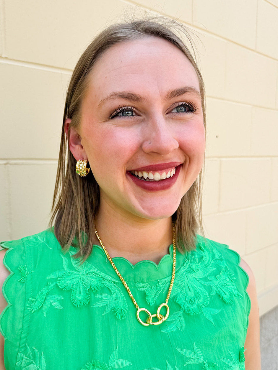 Gold-toned necklace with three statement chain links on a delicate rope chain—elegant, timeless, and made to last. Gold thick mini hoop earrings with gem accents, displayed on neutral background.