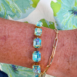 Bright gold-tone tennis bracelet featuring emerald-cut Aqua Aurora Borealis crystals from Sorrelli’s Octavia design.