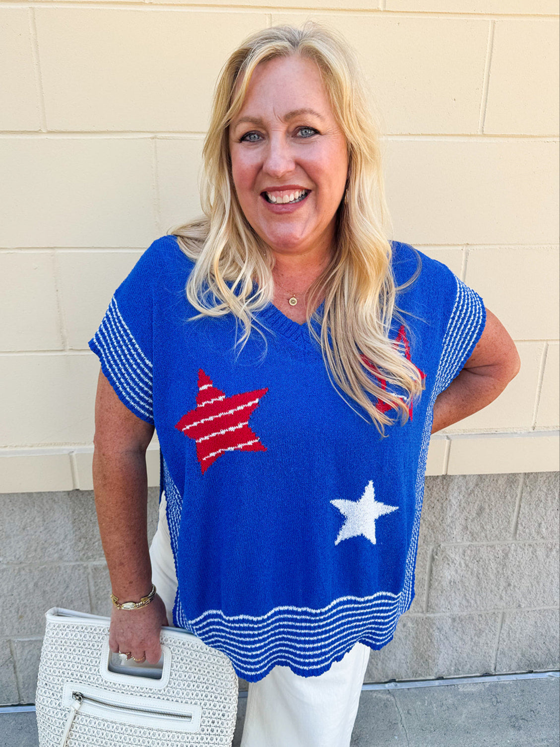Oversized blue poncho sweater with three Americana stars on front and white striped details, styled for patriotic summer events.
