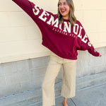 Boxy garnet crewneck sweatshirt featuring oversized gold plaid Seminoles lettering across the front and a Seminole logo on the left sleeve.