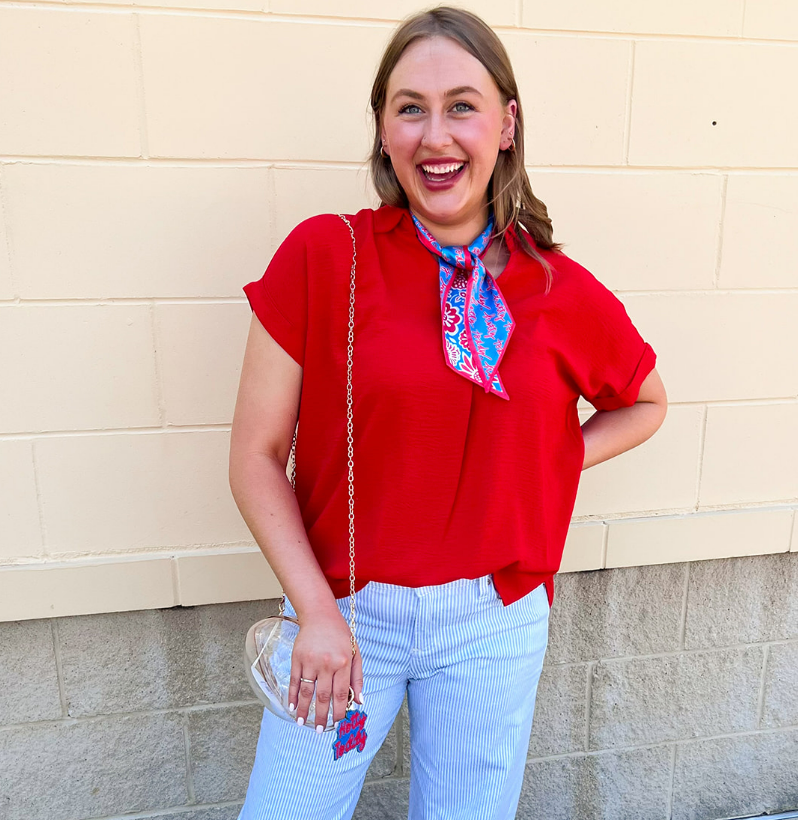 Red flowy woven top with collared neckline, drop shoulder short sleeves, and subtle V-neck detail.