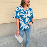 Lightweight linen blend top with a blue and white tropical print, featuring a V-neckline and relaxed fit for an easy, breezy warm-weather look