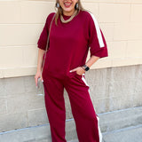 Garnet two-piece lounge set with flowy short sleeve top, wide-leg pants, and off-white stripe detailing.
