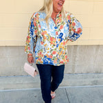 Floral chiffon blouse with frilled neckline, button front, dolman sleeves, and lightweight, flowy fit.
