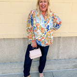 Floral chiffon blouse with frilled neckline, button front, dolman sleeves, and lightweight, flowy fit.