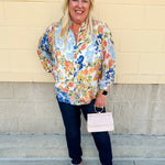 Floral chiffon blouse with frilled neckline, button front, dolman sleeves, and lightweight, flowy fit.