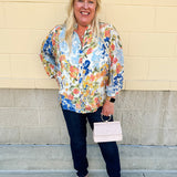 Floral chiffon blouse with frilled neckline, button front, dolman sleeves, and lightweight, flowy fit.