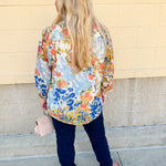 Floral chiffon blouse with frilled neckline, button front, dolman sleeves, and lightweight, flowy fit.