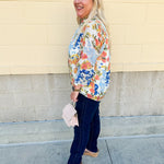Floral chiffon blouse with frilled neckline, button front, dolman sleeves, and lightweight, flowy fit.