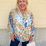 Floral chiffon blouse with frilled neckline, button front, dolman sleeves, and lightweight, flowy fit.