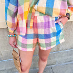 Rainbow plaid Bermuda shorts featuring a vibrant multicolor woven pattern and relaxed tailored fit.