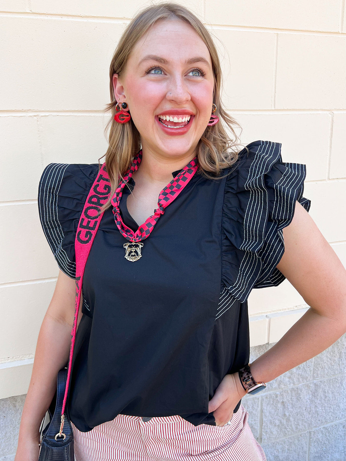 Black woven top with split neckline, short ruffle sleeves, and stitch detailing.