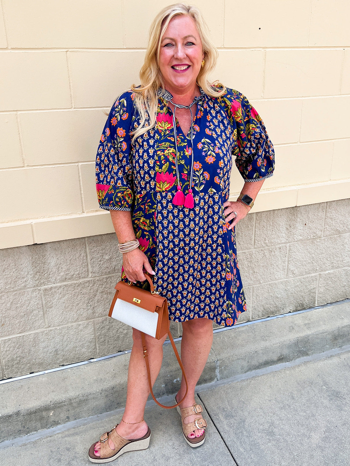 Navy colored midi dress with floral patterns and 3/4 sleeves with tassle neck ties hanging down