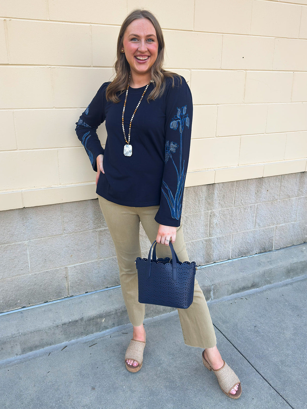 Navy blue sweatshirt with oversized light blue and white embroidered flowers covering both sleeves