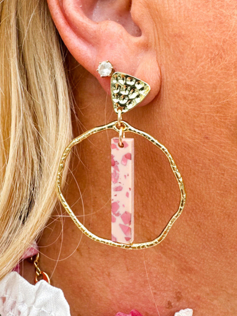 Hammered gold hoop earrings with pink acrylic stick flecked with darker pink, designed by Taylor Shaye.